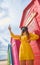 Teenager with a mask and glasses on the beach taking a selfie in the colorful huts. New normal concept