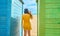 Teenager with a mask and glasses on the beach taking a selfie in the colorful huts. New normal concept