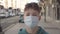 A teenager opens his eyes while standing in a medical protective disposable mask