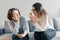 Teenager patient girl talking with professional psychotherapist in office. Girl looks into her phone ignores a psychologist.