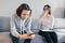 Teenager patient girl talking with professional psychotherapist in office. Girl looks into her phone ignores a psychologist.