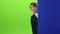 Teenager peeks out from behind and board curves of the face on a green screen. Slow motion