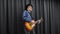 Teenager playing on guitar. Funny stylish musician playing on lead guitar. Happy smiling man lead guitarist playing electric guita