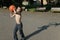 Teenager plays basketball in the street