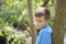 A teenager poses for a photographer while walking in the park. Thoughtful look.