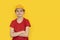 Teenager in protective helmet on yellow background. Boy dreams of future career in construction