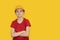 Teenager in protective helmet on yellow background. Guy dreams of future career in construction