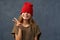 Teenager pulling down red hat, keeping eyes closed