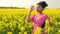 Teenager running and drinking water bottle in field of yellow flowers