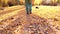 teenager\'s feet walking on autumn leaves