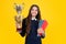 Teenager school girl with award winner trophy. Child hold books with gold trophy or winning cup isolated on yellow