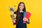 Teenager school girl with award winner trophy. Child hold books with gold trophy or winning cup isolated on yellow