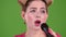 Teenager sings into the microphone. Green screen. Close up