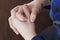 The teenager sits and clasps his hands. Close-up of hands.