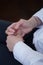 The teenager sits and clasps his hands. Close-up of hands.