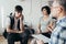 Teenager sits next to his mother during a meeting with therapists for children with problems