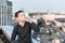 Teenager sitting on edge of the rooftop drinks water