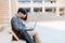 Teenager sitting on stair at college campus with school books and a laptop computer doing homework. Education concept