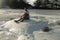 Teenager sitting on white sand at Tanjung Aan beach, Lombok, Indonesia. A young Asian man looks at the landscape