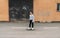 Teenager skateboarder boy riding on skateboard on asphalt road near a grunge graffiti wall. Youth generation Freetime spending