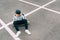 Teenager skateboarder boy with a skateboard sitting on asphalt playground and resting after he made tricks. Youth generation