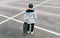 Teenager skateboarder boy with a skateboard standing on asphalt playground and resting after he made tricks. Youth generation