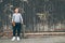 Teenager skateboarder boy standing beside a wooden grunge graffiti wall with skateboard and Water bottle flask. Youth generation