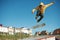 A teenager skateboarder does an flip trick in a skatepark on the outskirts of the city