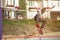 A teenager skateboarder does an ollie trick in a skatepark on the outskirts of the city