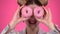 Teenager sniffs the cake and smile. Pink background. Close up. Slow motion