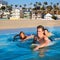 Teenager surfer boys and girls swimming ove surfboard