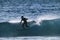 Teenager surfing at the wave in tenerife playa de las americas - white wetsuits and beautiful and perfect wave