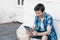 Teenager with tablet sitting near the wall