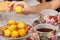 A teenager takes a wild apricots from a plate. Teacups with hot tea and with floral pattern, teapot, biscuits and plate with wild