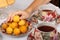 A teenager takes a wild apricots from a plate. Teacups with hot tea and with floral pattern, teapot, biscuits and plate with wild