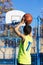 Teenager throwing a basketball into the hoop