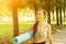 Teenager training in nature, young athletic woman goes to do sports with a yoga mat and fitness exercises in the park, healthy