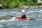 A teenager trains in the art of kayaking. Boat on rough river rapids. The child is skillfully engaged in rafting.