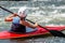 A teenager trains in the art of kayaking. Boat on rough river rapids. The child is skillfully engaged in rafting.