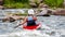 A teenager trains in the art of kayaking. Boat on rough river rapids. The child is skillfully engaged in rafting.