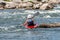 A teenager trains in the art of kayaking. Slalom on rough river rapids. The child is skillfully engaged in rafting.