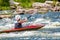 A teenager trains in the art of kayaking. Slalom on rough river rapids. The child is skillfully engaged in rafting.