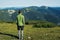 Teenager traveler is standing alone on alpine meadow