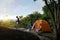 Teenager Travelers Pitch Vibrant Orange Tent on Cliff with a Natural View, Embracing Pristine Natural Views or Surrounded by