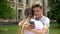 Teenager using cell phone while hugging girlfriend, absorbed by social networks