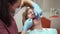 Teenager visits orthodontist lady puts aligners on boy teeth