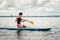 Teenager in a wet suit floats sitting a supsurf on the lake