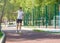 Teenager in white t shirt spends free time training skating in the city park. Boy looking on mobile phone.