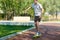 Teenager in white t shirt spends free time training skating in the city park. Practicing skills freestyle, making tricks.