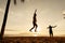 Teenagers balance on slackline silhouette